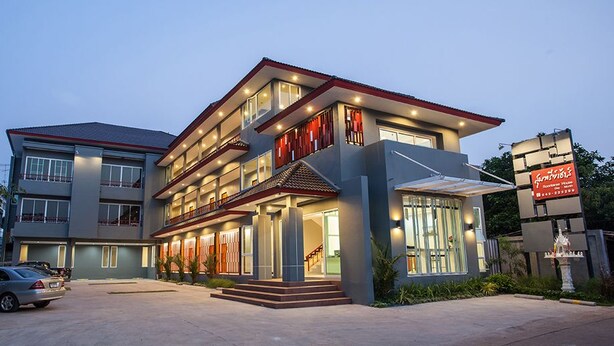 A modern hotel with multiple floors, large windows, and a well-lit entrance. - Soontree House (Udon Thani)