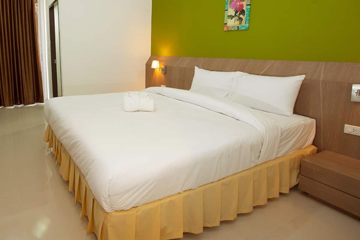 A hotel room with a bed, a desk, and a chair.