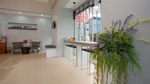 A modern hotel lobby with a seating area, a reception desk, and a large potted plant. - Soontree House (Udon Thani)