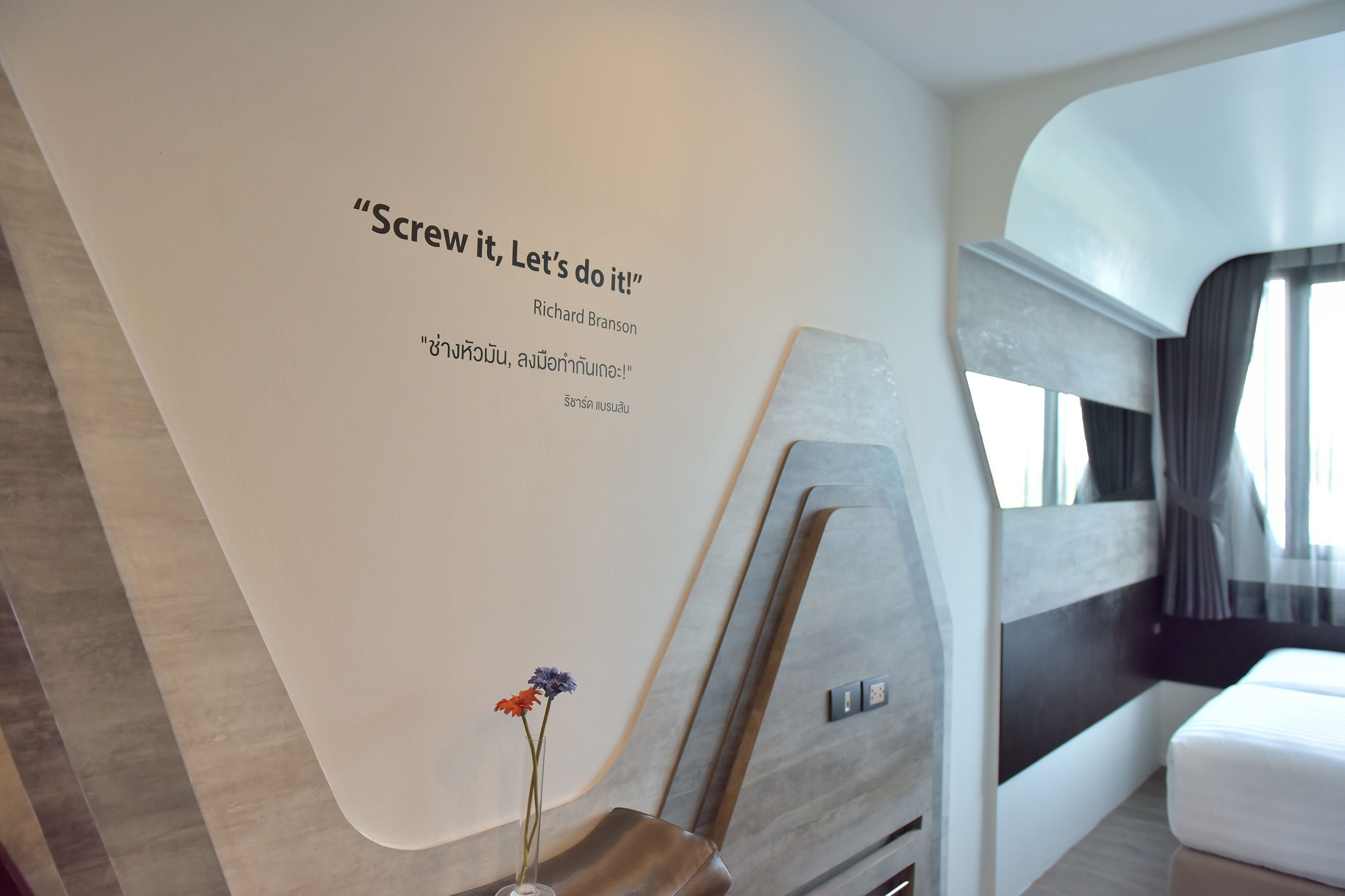 Un intérieur moderne agrémenté d’une citation inspirante sur le mur, un design minimaliste et un lit offrant une vue agréable.