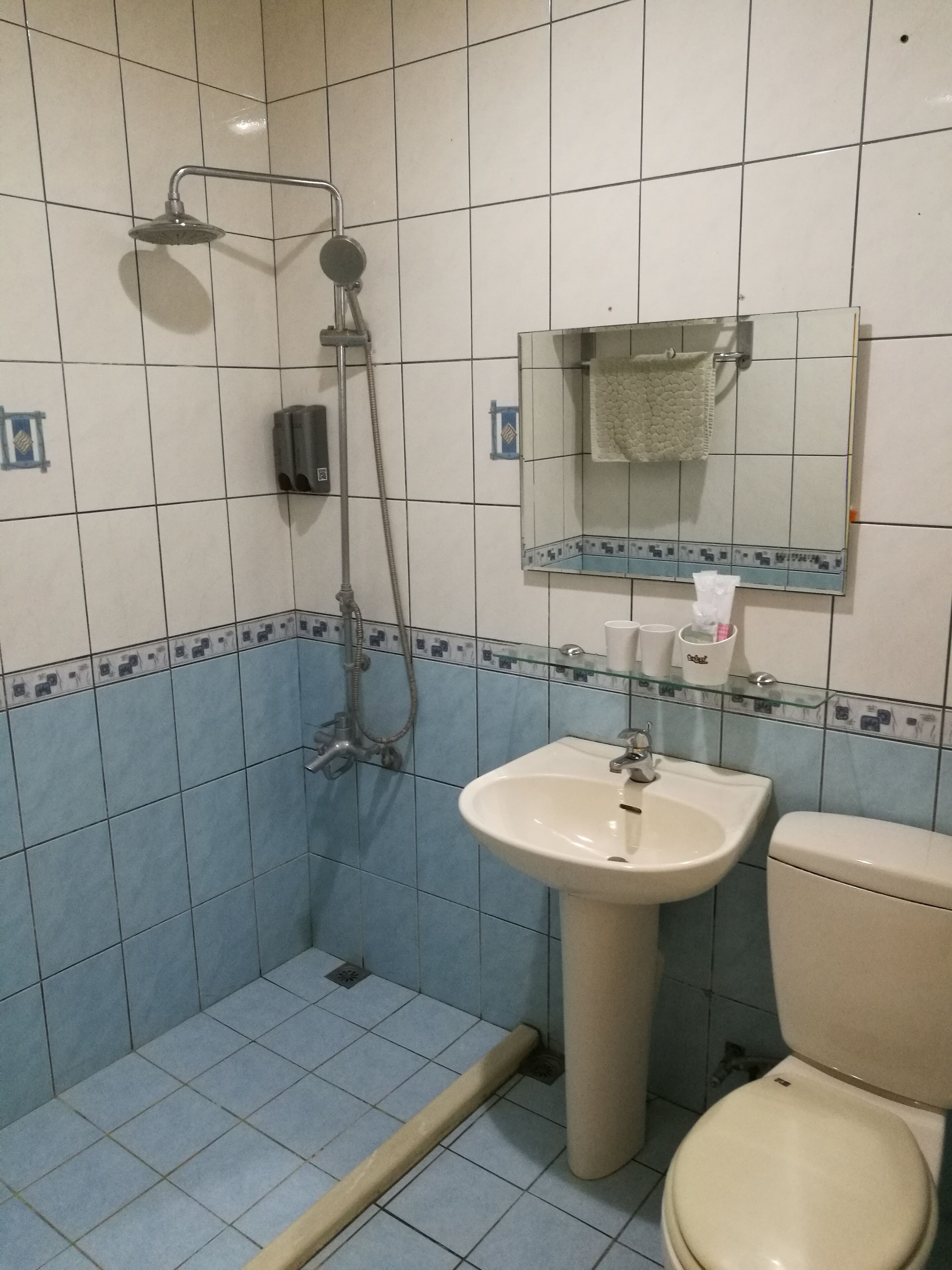 A bathroom with a shower, sink, and toilet.