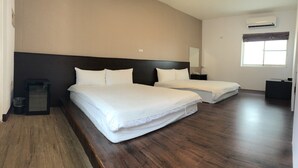 Une chambre d’hôtel avec deux lits, un plancher en bois, un grand miroir, un appareil de climatisation et une fenêtre avec des rideaux.