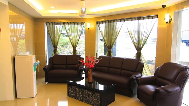 A modern living room with a sofa set, a coffee table, and a refrigerator.