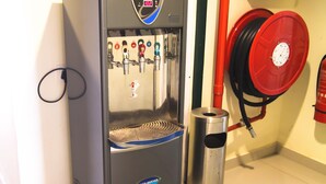A water dispenser with a digital display, a hose reel, and a fire extinguisher.