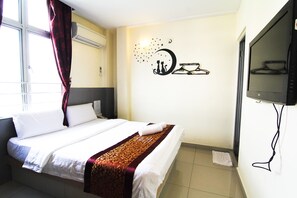 Une chambre d’hôtel avec un lit, une télévision et un élément décoratif mural.