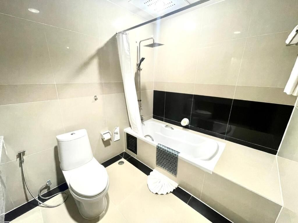 A modern bathroom with a toilet, sink, and bathtub.