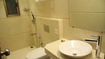 Une salle de bain équipée de toilettes, d’un lavabo et d’une douche.