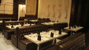Restaurante com assentos em cabines e mesas preparadas para refeições.
