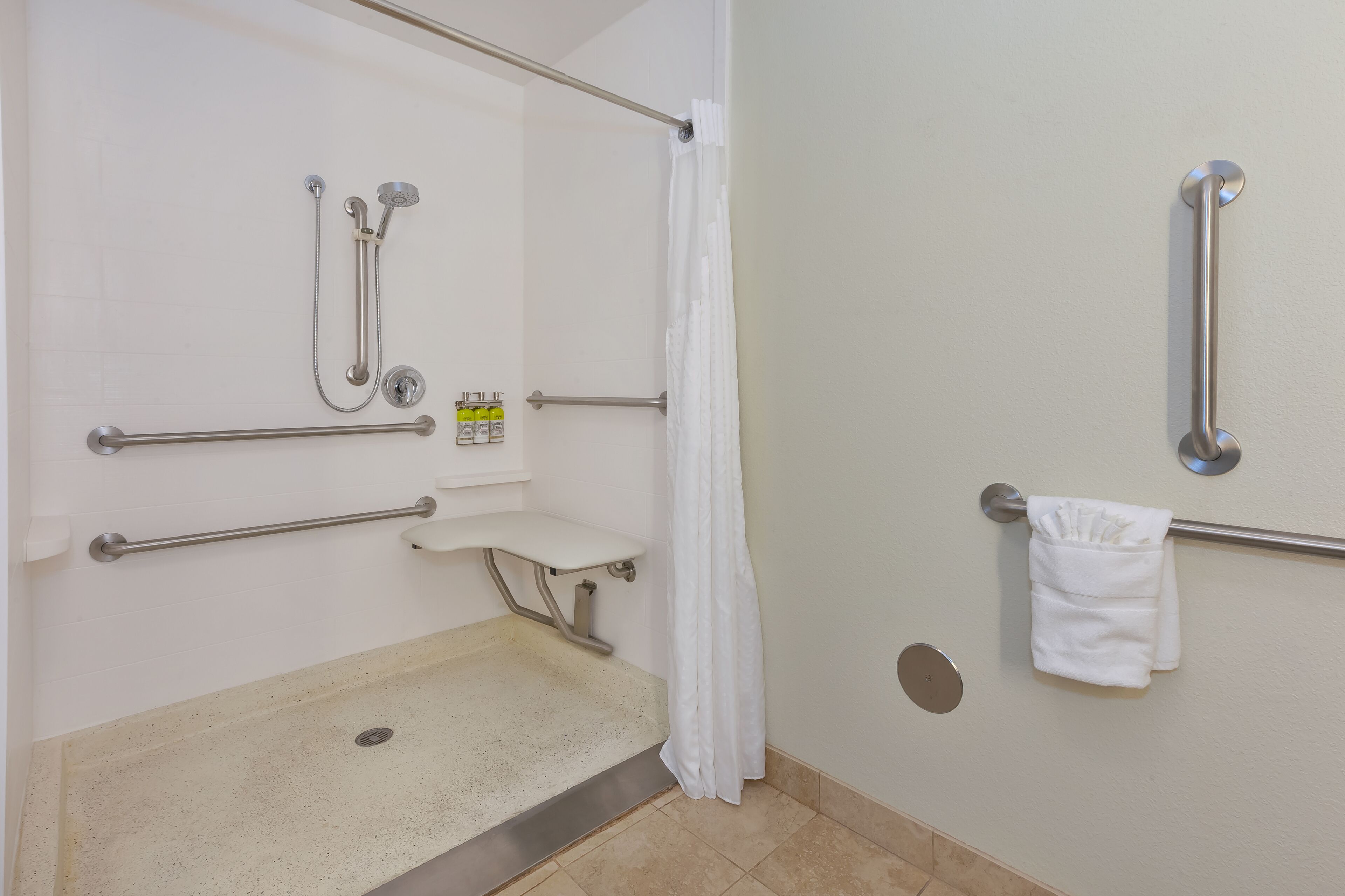 A handicap-accessible bathroom with grab bars, a shower, and a toilet.