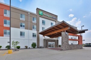 Edificio de Holiday Inn Express con entrada cubierta y fachada de piedra.