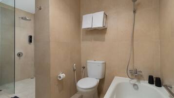 Een moderne badkamer met een douchecabine van glas, een toilet, een bad en een handdoekhouder.