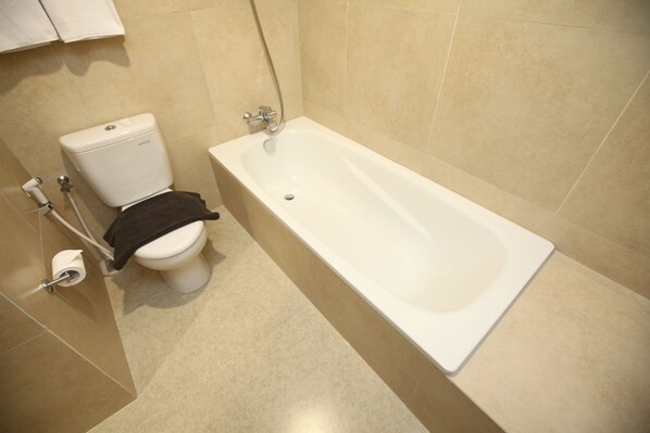 Un baño con inodoro, bañera y ducha.