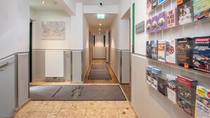 A hallway with a map on the wall, a radiator, and a doormat.