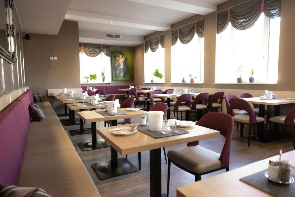 Ein Restaurant mit mehreren Tischen und Sitzgruppen, einige mit Kissen.