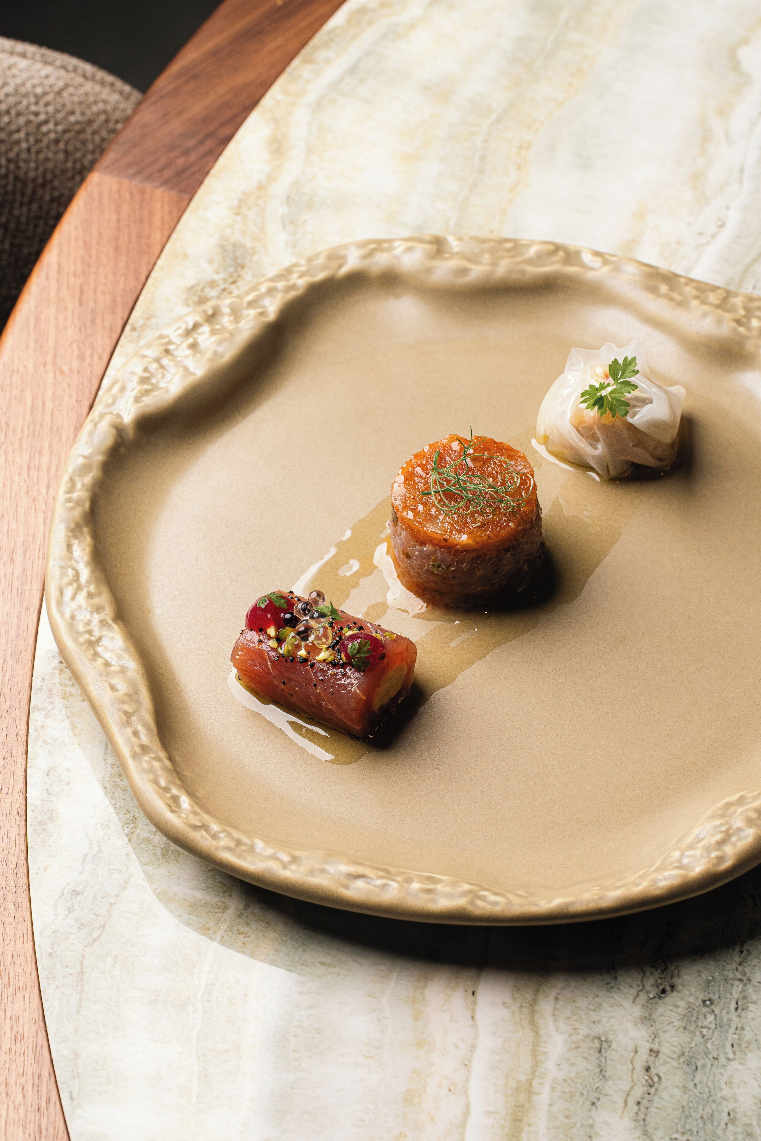 A plate with three food items on a marble surface.