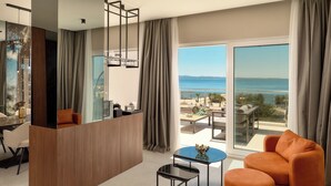 A modern living room with a wooden partition, a round coffee table, an orange sofa, and a view of the sea through large windows.