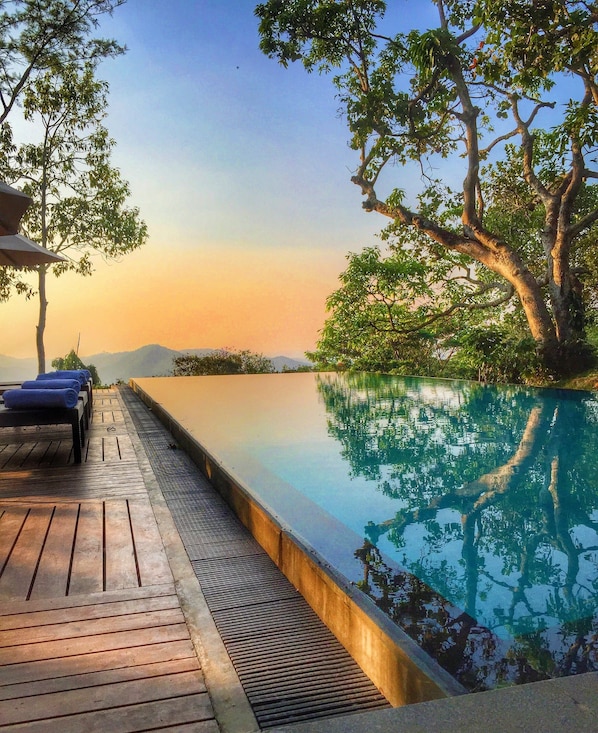 Una piscina cubierta, una piscina al aire libre, sombrillas, tumbonas