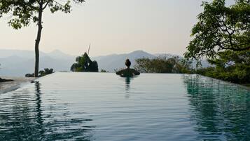 Ein ruhiger Infinity-Pool mit freiem Blick auf ferne Berge.