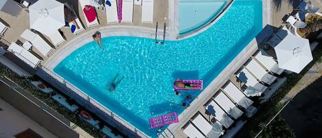 Una piscina al aire libre, tumbonas