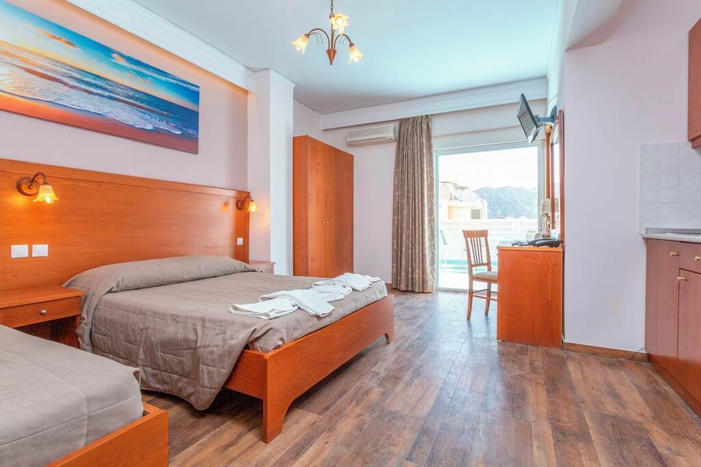 Una habitación de hotel con una cama de madera, un escritorio y vistas a la ciudad.
