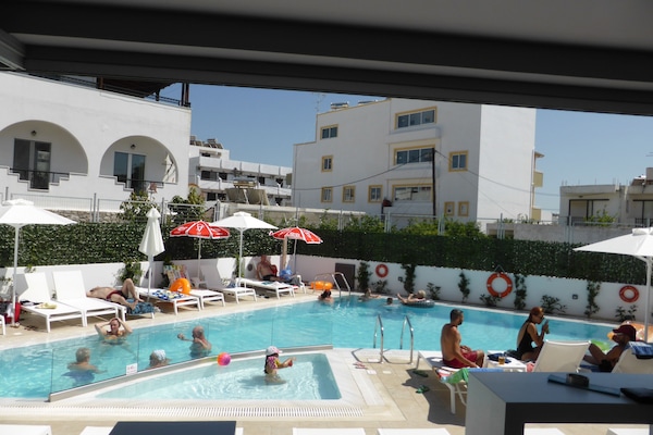 Una piscina al aire libre, tumbonas