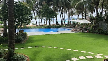 Una piscina al aire libre, sillones reclinables de piscina