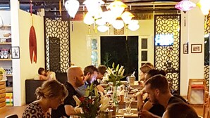 A restaurant with a long communal table, hanging lanterns, and a patterned wall. - Peppercorn Beach (Phu Quoc)