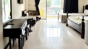Ein Hotelzimmer mit einem Bett, einem Sofa, einem Schreibtisch und einem Balkon mit Geländer.