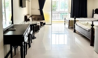 Quarto de hotel com cama, sofá, escrivaninha e varanda com guarda-corpo.