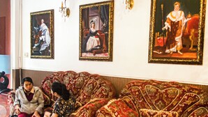 Ein Wohnzimmer mit einem großen, gemusterten Sofa, einem Glastisch und einer Wand-Klimaanlage.