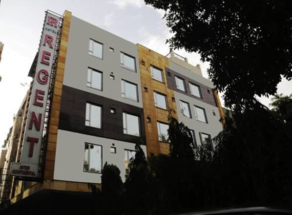 A multi-story hotel with a modern architectural design, featuring a mix of window styles and a prominent sign on the facade. - Hotel Regent Intercontinental (New Delhi)