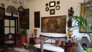 A traditional room with a sofa, decorative items, and a large painting. - On The House - Bed and Breakfast (New Delhi)