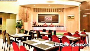 A restaurant with a reception area, multiple tables, and chairs. - Grand HAP Hotel (Surakarta)
