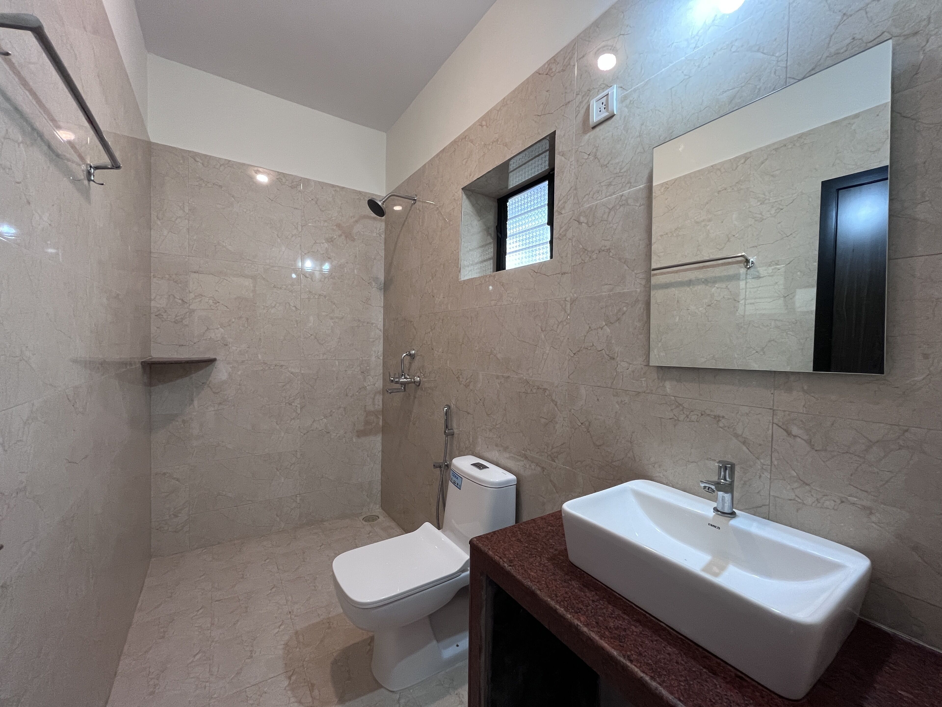 Un baño moderno con cabina de ducha, inodoro y lavamanos.