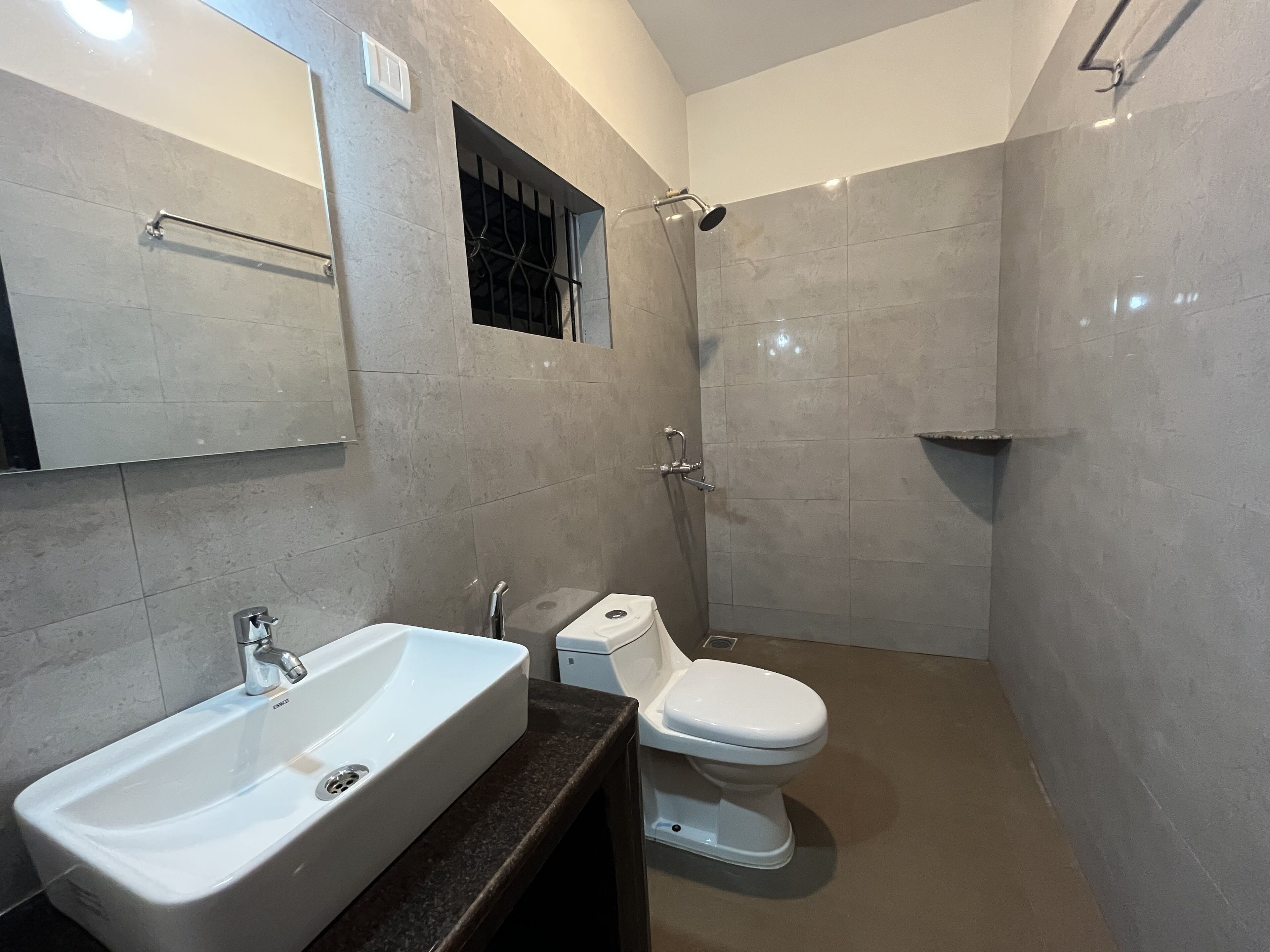 A bathroom with a white sink, toilet, and shower.
