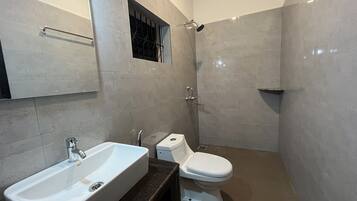 A bathroom with a white sink, toilet, and shower.