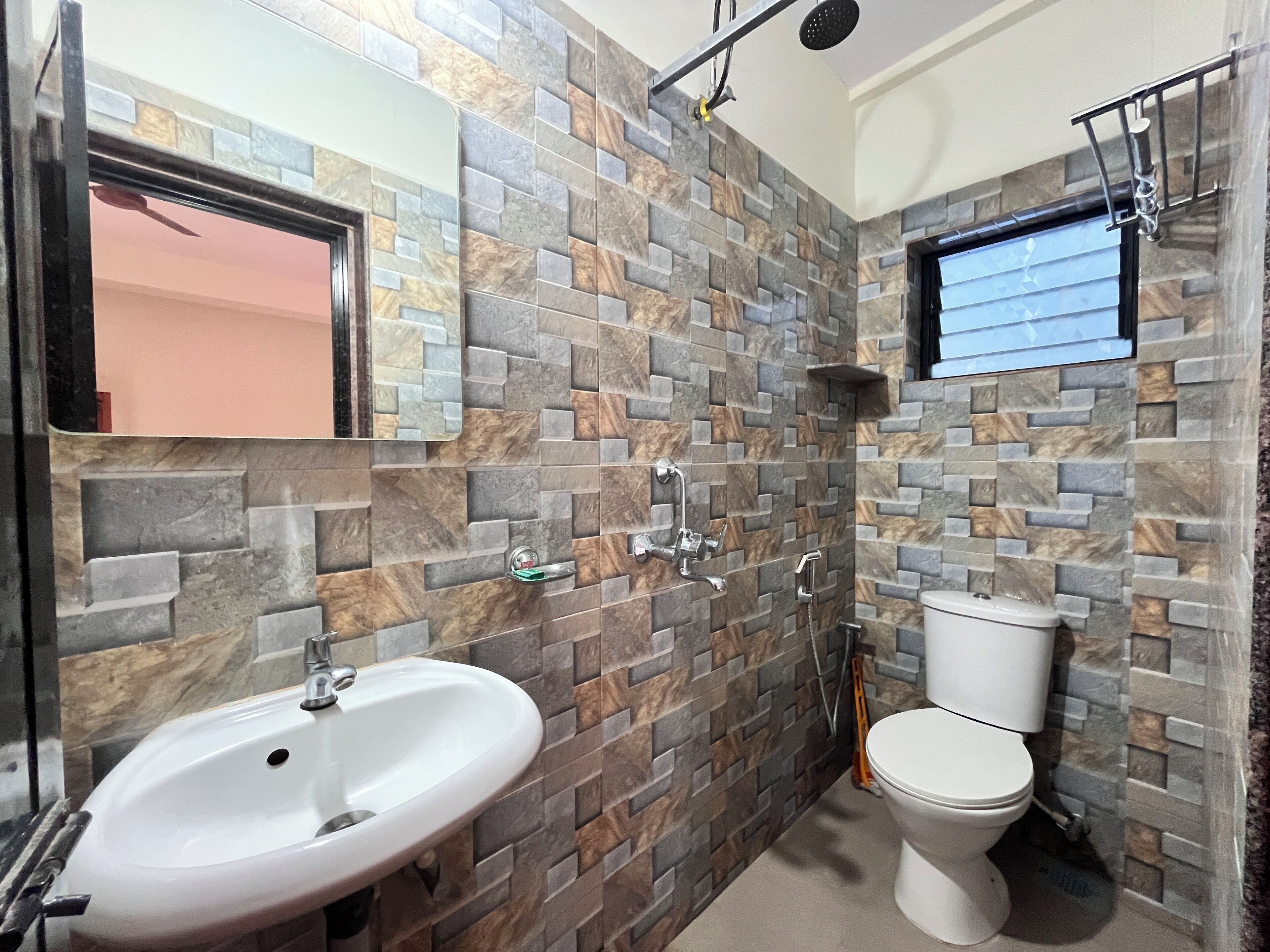 Un baño con lavamanos blanco, inodoro y zona de ducha.