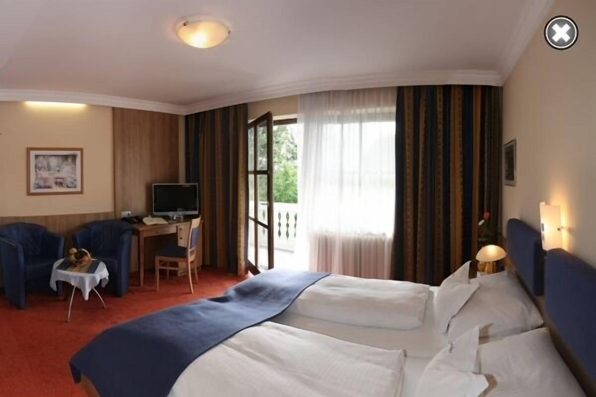 Une chambre d’hôtel équipée d’un lit, d’un bureau, d’une chaise et d’un téléviseur.