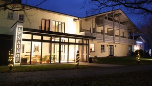 Un immeuble de deux étages doté d’une grande façade en verre et d’un balcon à l’étage supérieur.
