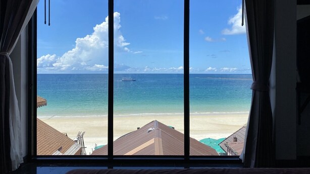 A room with a large window overlooking a beach and ocean. - Sinsamut Koh Samed Hotel (Rayong)