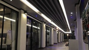 A corridor with glass doors, recessed lighting, and a reception desk. - Sinsamut Koh Samed Hotel (Rayong)