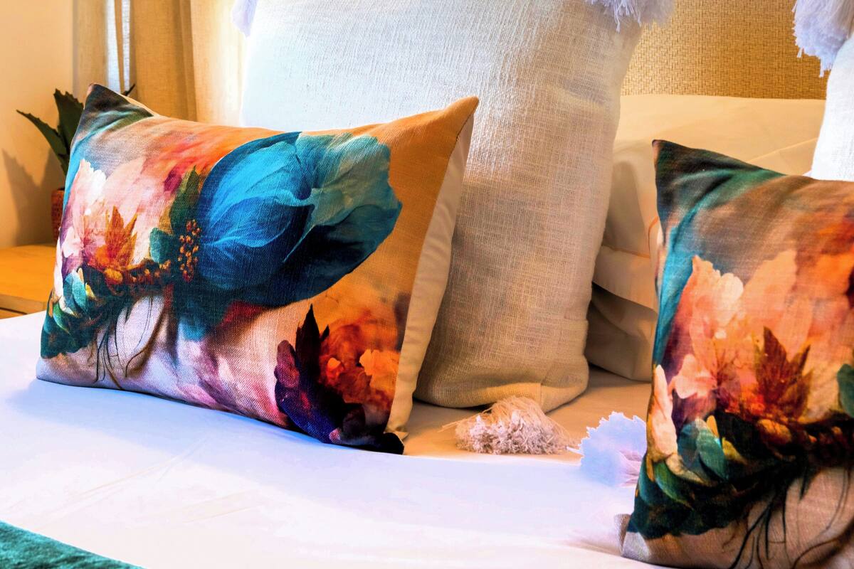 Habitación de hotel con una cama, una lámpara colgante y un cuadro en la pared.