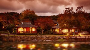 A lakeside resort with wooden cabins and a stone wall.