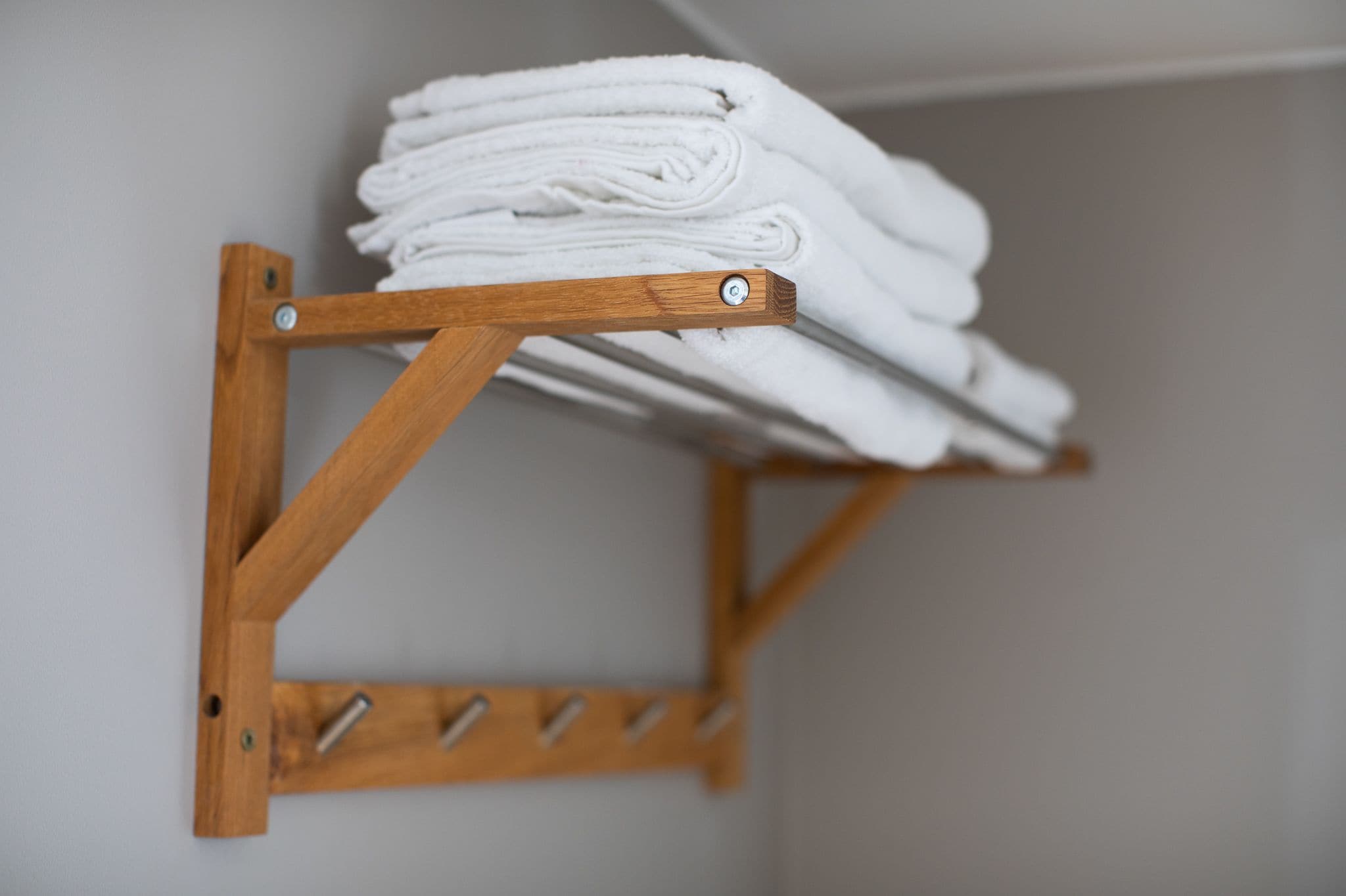 A wooden towel rack with folded towels.