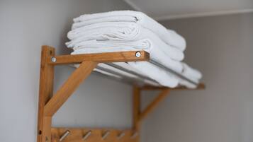 A wooden towel rack with folded towels.