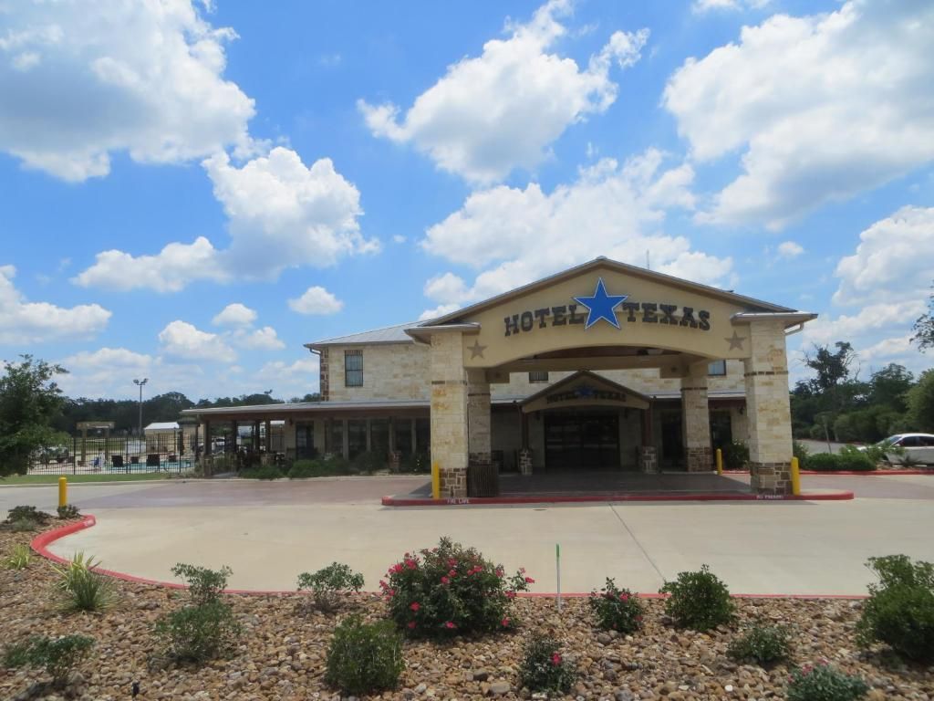 A hotel entrance with a clear sky and a star emblem.