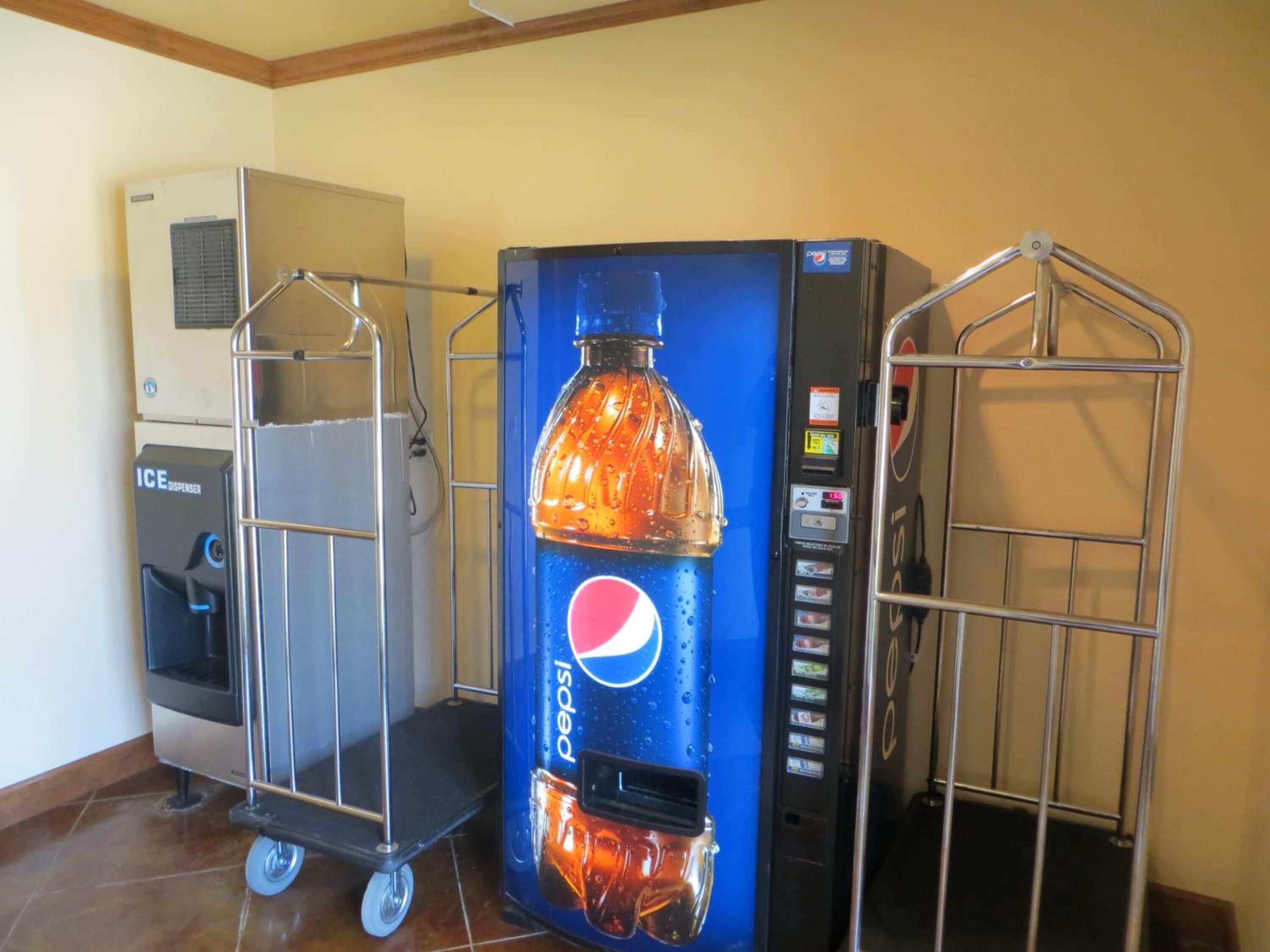 Máquina expendedora con logotipo de Pepsi, dispensador de agua y un carrito.
