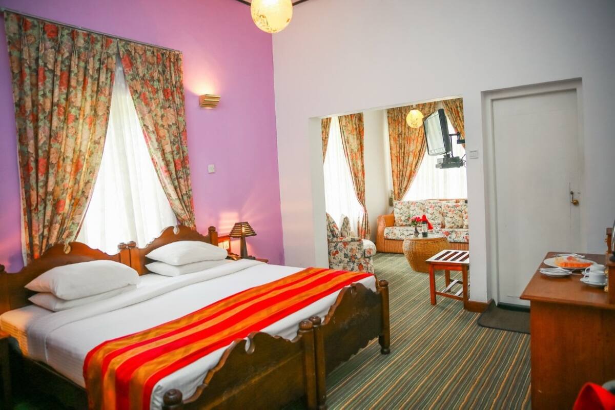 Een hotelkamer met een bed, een bureau, een stoel en een bank.