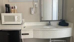 A compact kitchenette with a microwave, coffee maker, and a small refrigerator. - Economy Inn (St. Augustine)