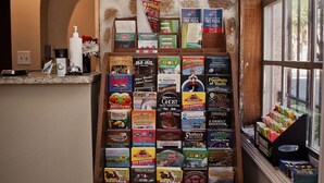 A display of books and magazines in a bookstore with a stone wall and a window in the background. - Economy Inn (St. Augustine)